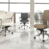 Global Accord Chairs - Three Global Accord chairs in a sunny office with high windows. A white upholstered high back and meshback Accord chair faces eachother. Further back is a black mid-back model of Accord chair.
