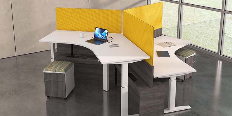 modern office cubicles with yellow sound partitions and a laptop with a coffee mug