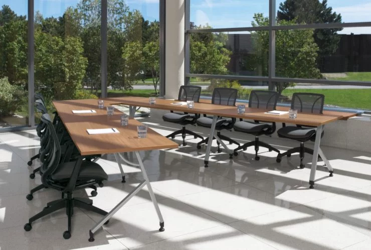 training tables in an open office with large windows and natural light and black chairs