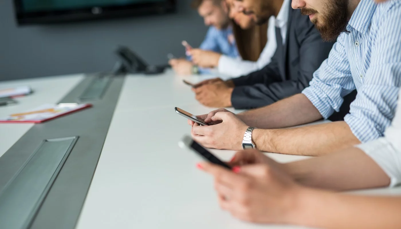 line of business people on their phones at a conference table