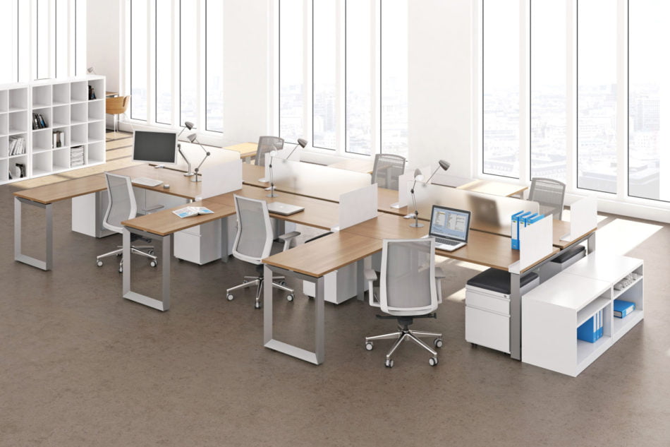 Studio photography of AMQ's Icon Benching. There is two 6-Pack single run workspaces, each with a green cushioned chair placed at the desk. It is using a walnut laminate. Another part of the desk juts out. The sun is shining in from the window beyond.