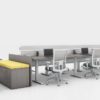 Global's 6-person power beam desks on a white studio set. Each workstation has a laptop open, with glass paneling for privacy. At one end is a cabinet with sunflower yellow cushions, and a square Swap table.