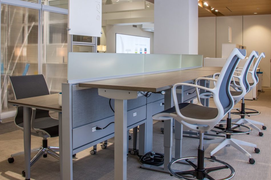 Global's 6-person power beam desks in a large office space. Three workstations are set up with the Foil tables adjusted higher than the three workstations facing it.