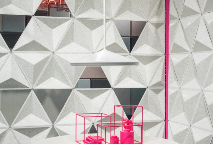 Studio photography into a corner, formed by two sets of Aircone acoustics. A round white table holds a pink wire display. The foam material forms geometric shapes.