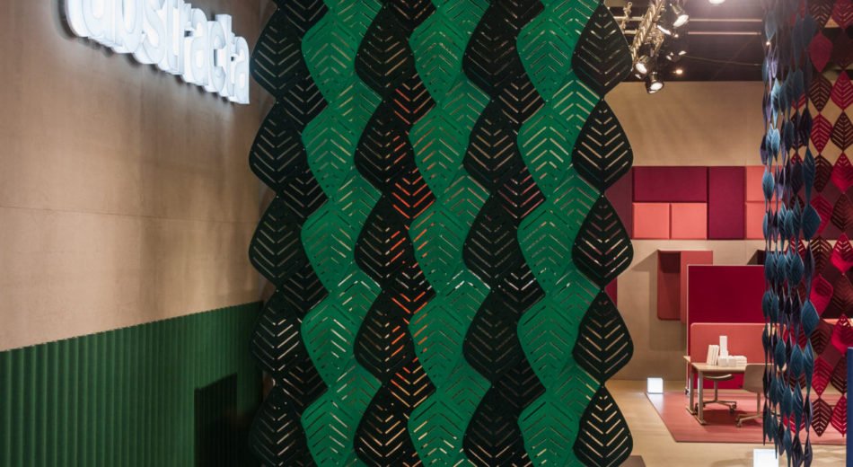 Studio shot of two sets of Airleaf acoustics forming partitions for interiors. One wall uses a mix of green and black Airleaf pieces. Towards a guest seating area, a corner is formed by Airleaf acoustics in red and blue colors.