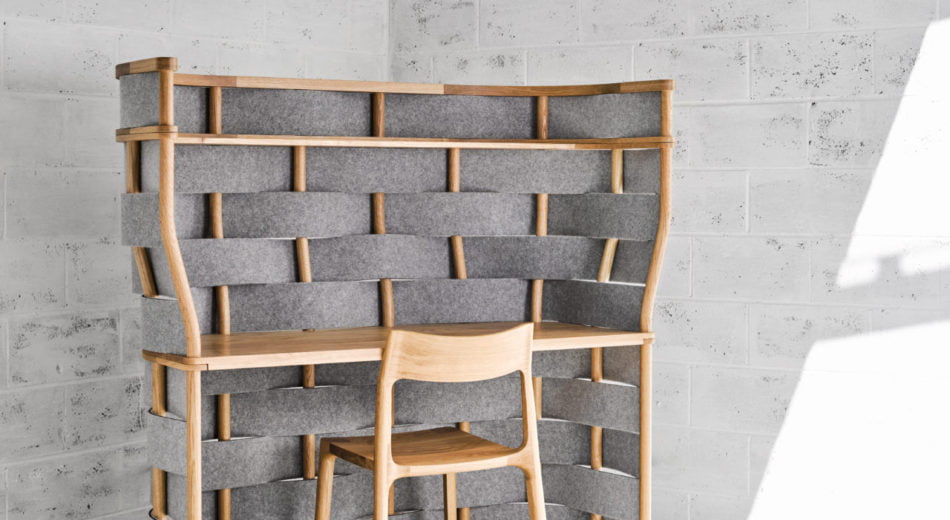 Studio shot of Bower privacy screening on a single workstation. This desk has been placed in the corner and has wooden accents to match the desk and chair.