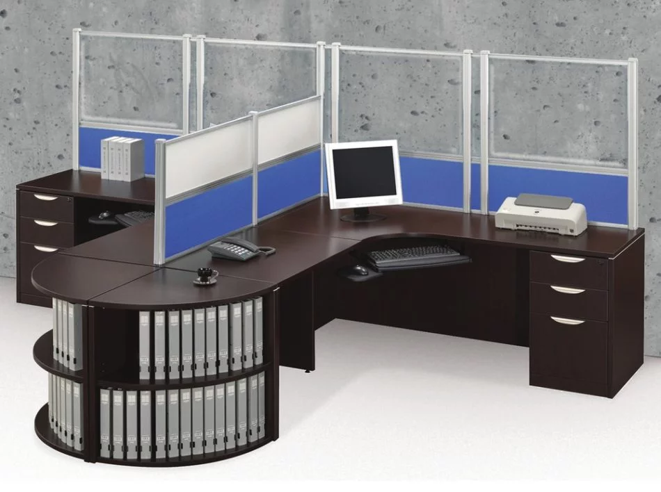 Tall Border (model) screens line the back of two L-shaped desks. Each screen uses clear acrylic, with a blue fabric panel at the bottom. Two shorter screens divide the desks on the side, with the top panels using frosted acrylic. Each desk has a computer monitor, with a phone at the side.