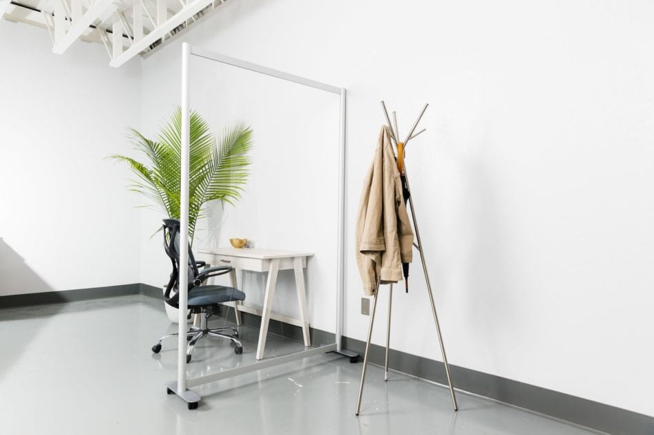 Open style Split model screen at the end of a small work table. On the other side is a tripod-style coatrack.