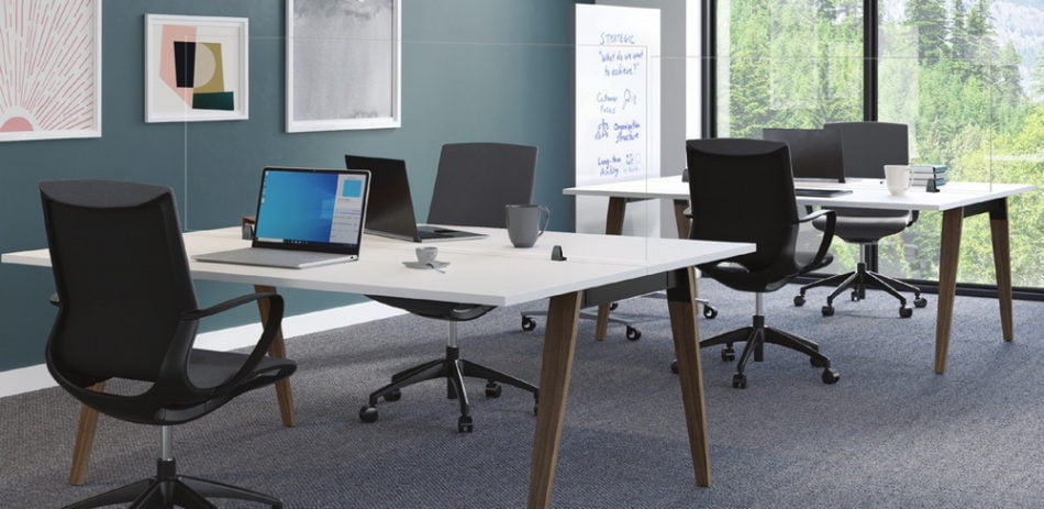 Looking to one side of a small, open office space. Straight (model) screens are placed between seating that faces one another, for each of the two tables. Windows look to trees outside.