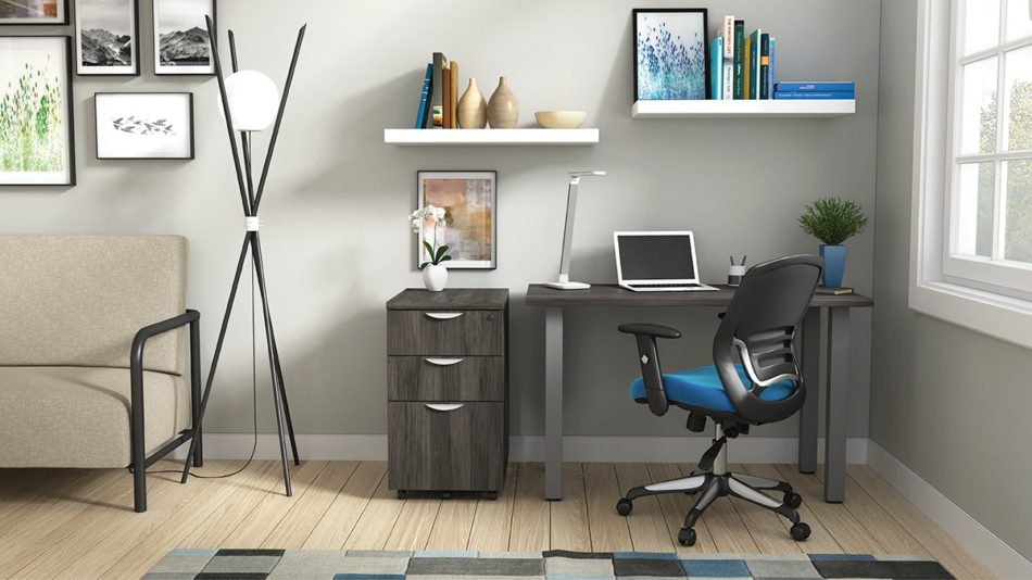 Studio shot of OTG's Home Office Setup, which has a 24" x 48" work table placed in the corner by the window. At the left is a set of pedestal drawers. The third (top) drawer has a lock on it. Both the desk and pedestal drawers are finished in an _____. A simple mesh-back office chair is pulled up to the laptop, with a LED lamp next to it.