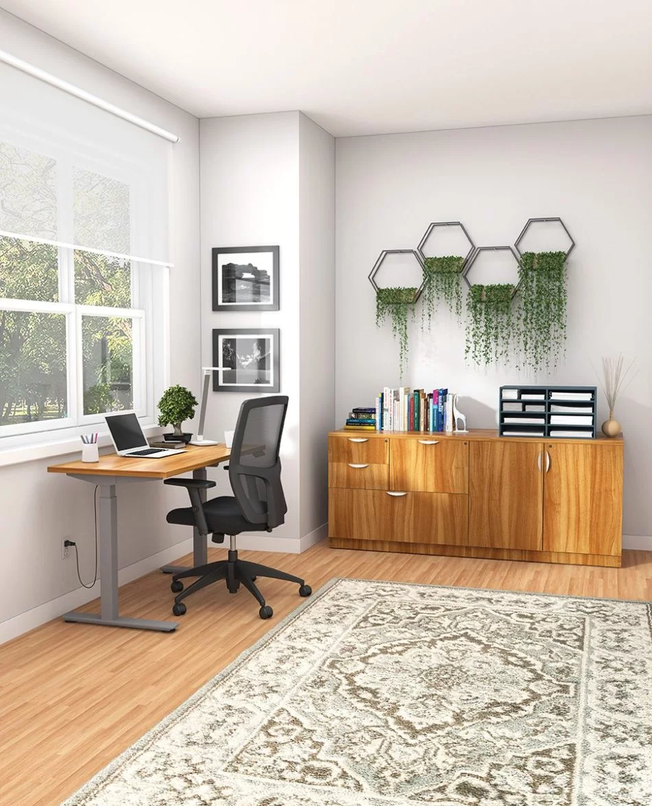 Studio shot of OTG's Home Office Setup, which has a height-adjustable work desk with a tungsten colored frame. To the side of the mesh back chair is the included mixed storage unit, with different drawer sizes. Both surfaces are finished in an Autumn Walnut finish.