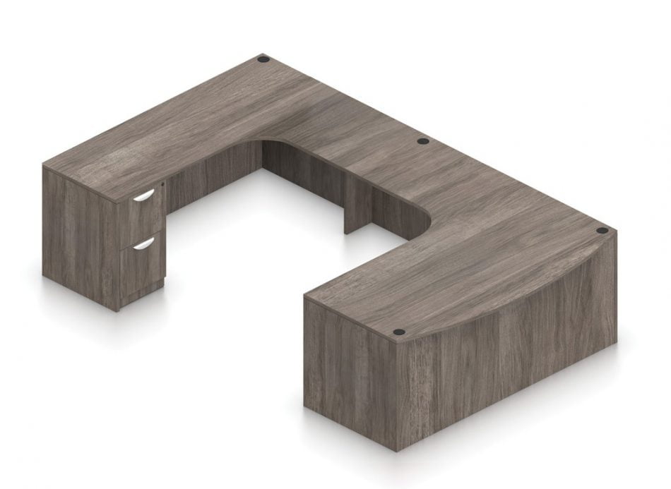 Orthographic view of an Offices to Go set of desking, using Layout B. This set consists of a 71" wide desk, with a curved bow front. A matching width credenza is arranged just across, with a 36" wide flush bridge spanning in between. At the outside of this layout is a set of pedestal drawers, with the second (top) drawer sporting a lock. This desking set is shown in an Artisan Grey finish.