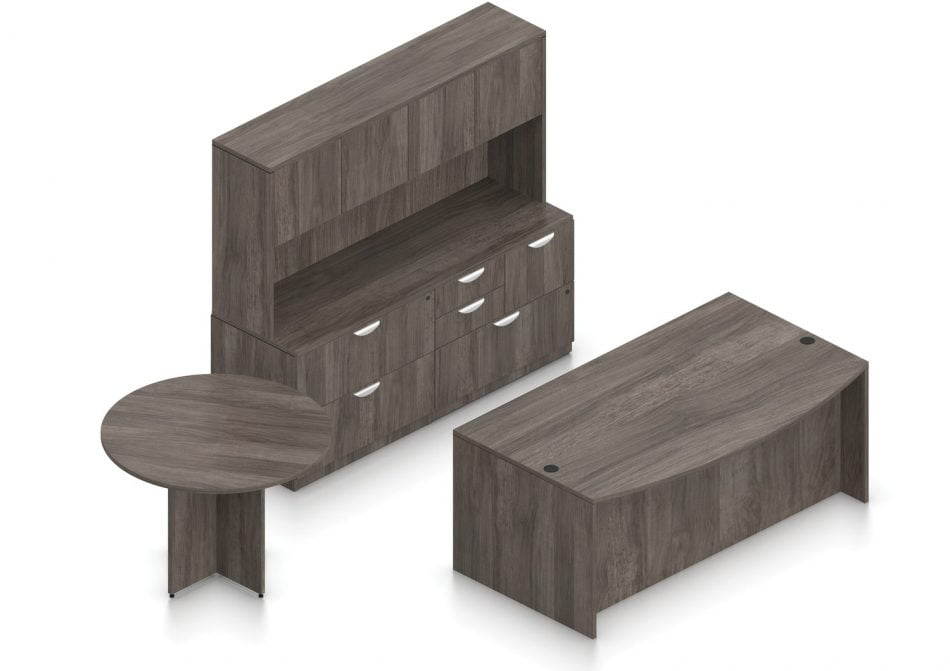 Orthographic view of an Offices to Go set of desks and table, using Layout H. This set consists of a 71" bowed front style desk, and a 42" round table. Two pedestal drawer sets are placed underneath the front desk. The cabinet behind it has three lateral file drawers, and a set of smaller sized drawers on one corner. A common countertop offers a work surface. The hutch above has two double doored cabinet storage areas. Layout H is shown here in an Artisan Grey finish.