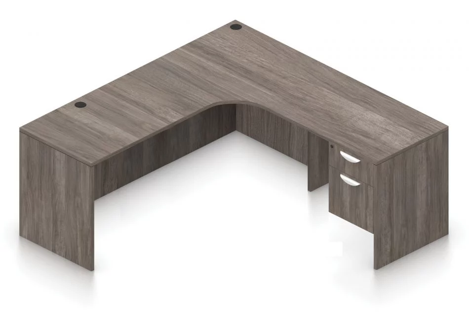 Orthographic view of an Offices to Go 71" corner desk with left side extension. Its inner edge is curved, and it has a set of two hanging office drawers to the right of it, with a lock on the top. This layout is featured in an Artisan Grey finish.