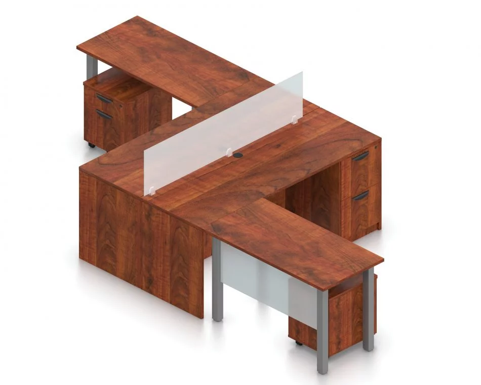 Orthographic view of an Offices to Go set of desking, using Layout 6. This set consists of two L shape workstations, adjoined at the back with an acrylic screen in-between. The 48" wide metal table extends at one side, with an acrylic privacy screen between the tungsten legs. At the right is a pair of hanging file drawers.. An additional pedestal file drawer has been rolled underneath the metal table. This layout is shown here in an American Dark Cherry finish.