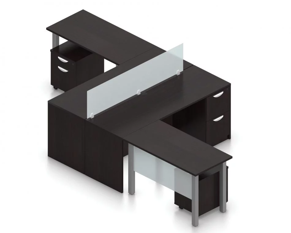 Orthographic view of an Offices to Go set of desking, using Layout 6. This set consists of two L shape workstations, adjoined at the back with an acrylic screen in-between. The 48" wide metal table extends at one side, with an acrylic privacy screen between the tungsten legs. At the right is a pair of hanging file drawers.. An additional pedestal file drawer has been rolled underneath the metal table. This layout is shown here in an American Espresso finish.
