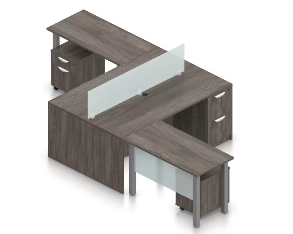 Orthographic view of an Offices to Go set of desking, using Layout 6. This set consists of two L shape workstations, adjoined at the back with an acrylic screen in-between. The 48" wide metal table extends at one side, with an acrylic privacy screen between the tungsten legs. At the right is a pair of hanging file drawers.. An additional pedestal file drawer has been rolled underneath the metal table. This layout is shown here in an Artisan Grey finish.