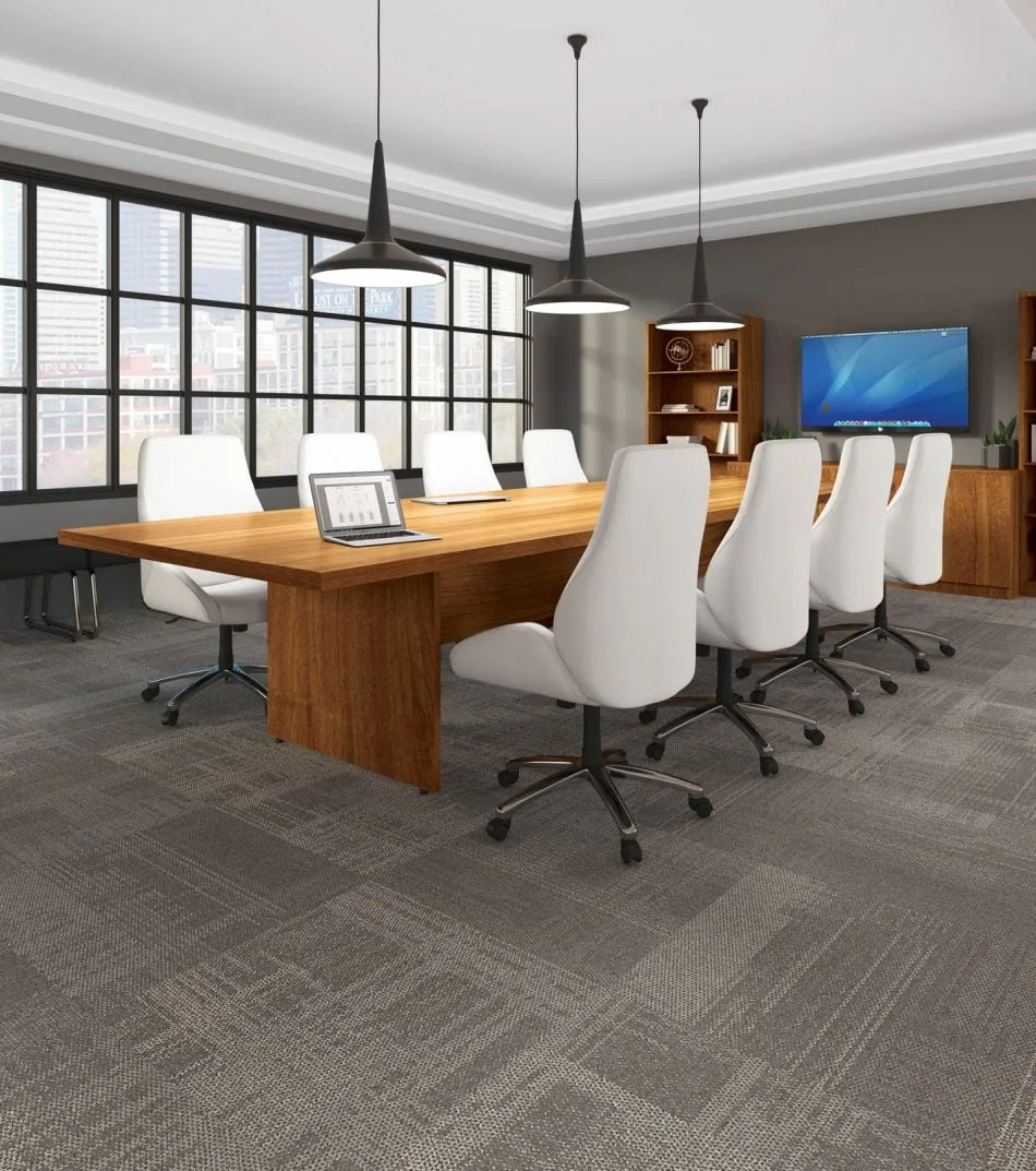 Studio photography of an Offices to Go conference room, with large paned windows. A 144" long rectangular conference table is in the center, with 4 high back plush chairs placed at each side of it. At the head of the table is a set of bookcases and storage cabinets along the wall. A flat screen monitor is placed on the surface above. The furniture is using an Autumn Walnut finish.
