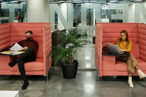 Two private cubicles with a man and lady working in them