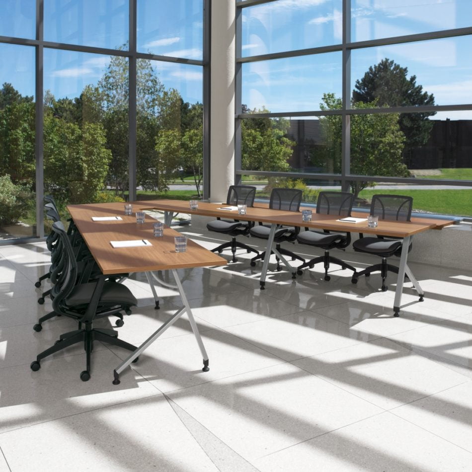 training tables in an open office with large windows and natural light and black chairs