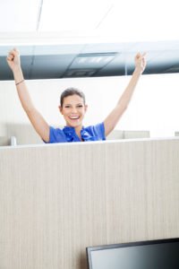 woman in cubicle workstation smiling and standing