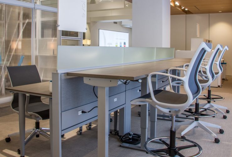 Global's 6-person power beam desks in a large office space. Three workstations are set up with the Foil tables adjusted higher than the three workstations facing it.