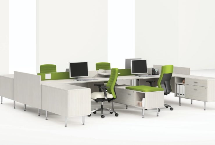 Global's 4-person sidebar benching in a stark white studio set. Each workstation has a flat screen monitor and a green backed rolling chair. The desktop and returns on the side are finished in a white finish.